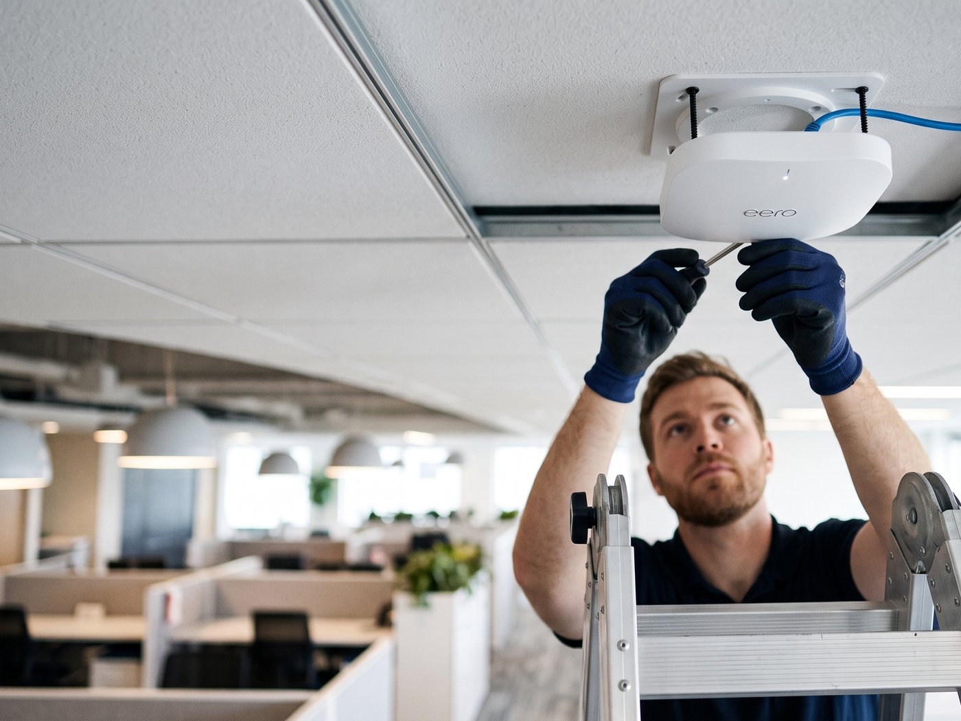 Technician installing a ceiling-mounted wireless access point