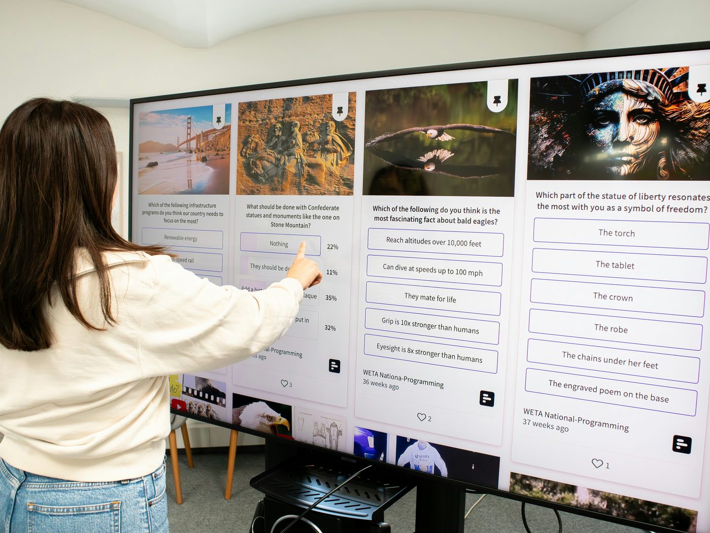 A person interacting with a large digital signage display in an office