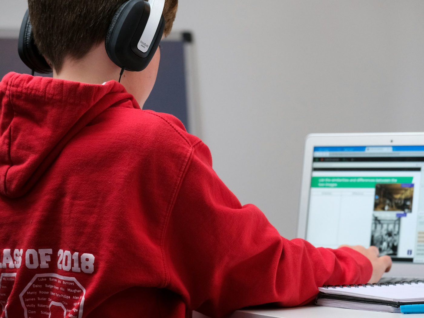 A student in headphones working on a laptop