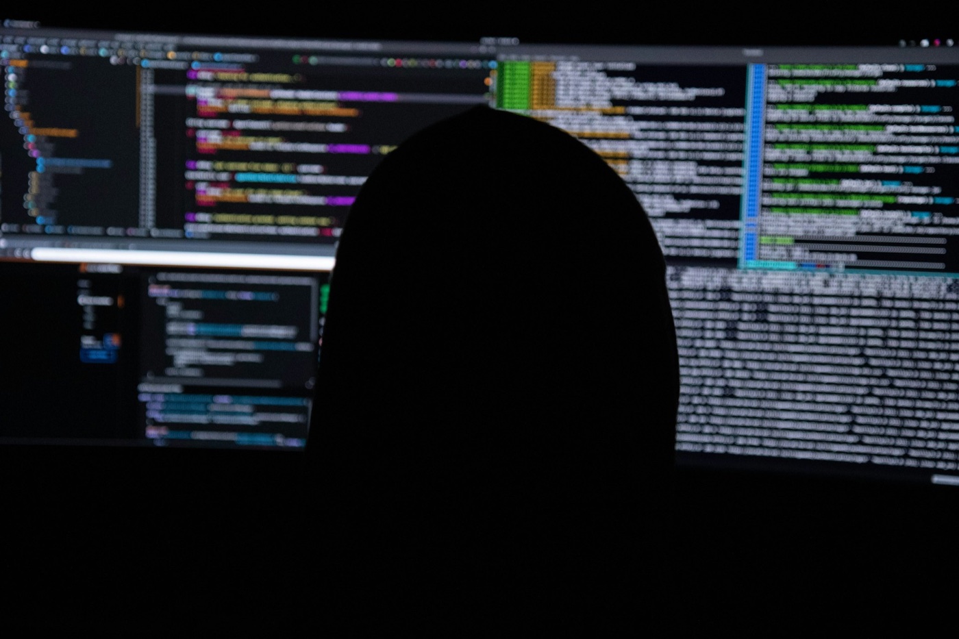 Security analyst monitoring live threat activity across multiple code displays